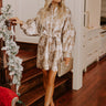 Woman wearing a chic pink and gold floral jacquard mini dress, styled with delicate gold sandals and a matching clutch, ideal for fall gatherings and holiday events.